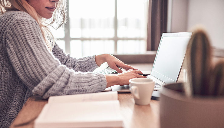 Junge Frau arbeitet am Laptop