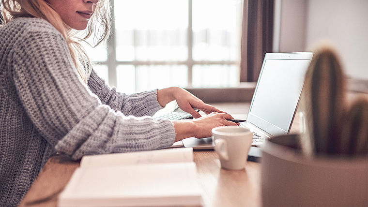 Junge Frau arbeitet am Laptop