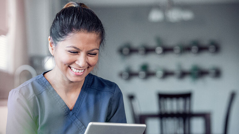 Therapeutin plant Krankheitsvertretung mit Tablet in digitaler Praxissoftware