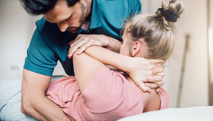 Physiotherapeutische Behandlung einer jungen Frau am Rücken
