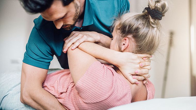 Physiotherapeutische Behandlung einer jungen Frau am Rücken