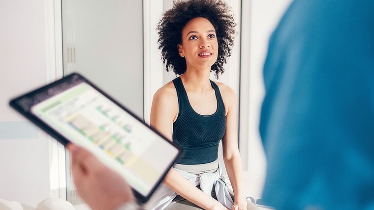 Patientin im Gespräch mit einem Therapeuten mit Tablet