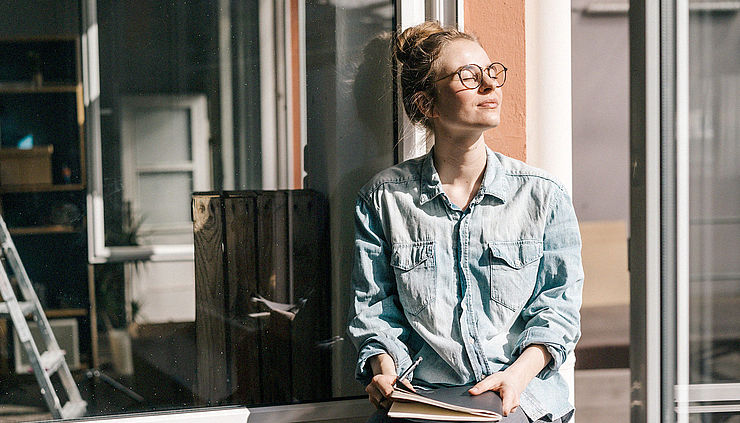 Frau mit Tagebuch entspannt sich in der Sonne