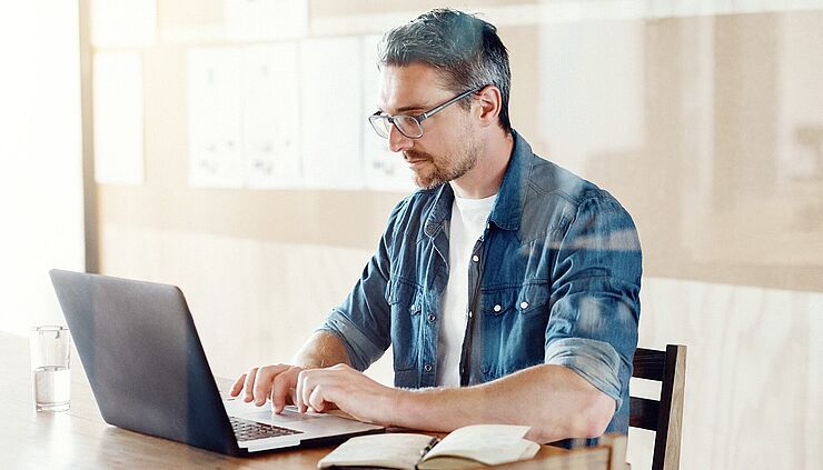 Ein Praxisinhaber erkundigt sich an seinem Laptopt zu einem Wechsel der Praxisverwaltungssoftware.