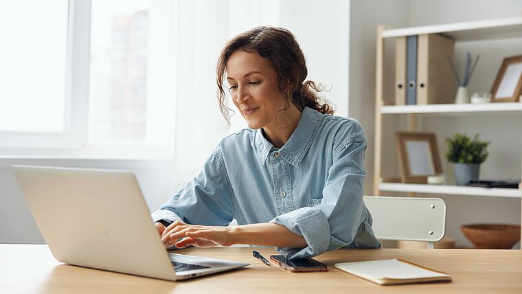 Physiotherapeutin arbeitet am Laptop und füllt dort möglicherweise einen TI-Erstattungsantrag aus