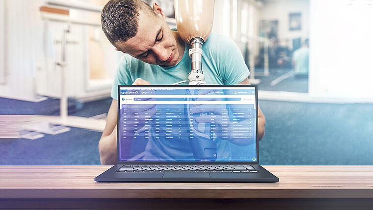 Bild von einem Hilfsmittelerbringer, hinter einem Laptop mit der Abrechnungssoftware Optica Omnia.